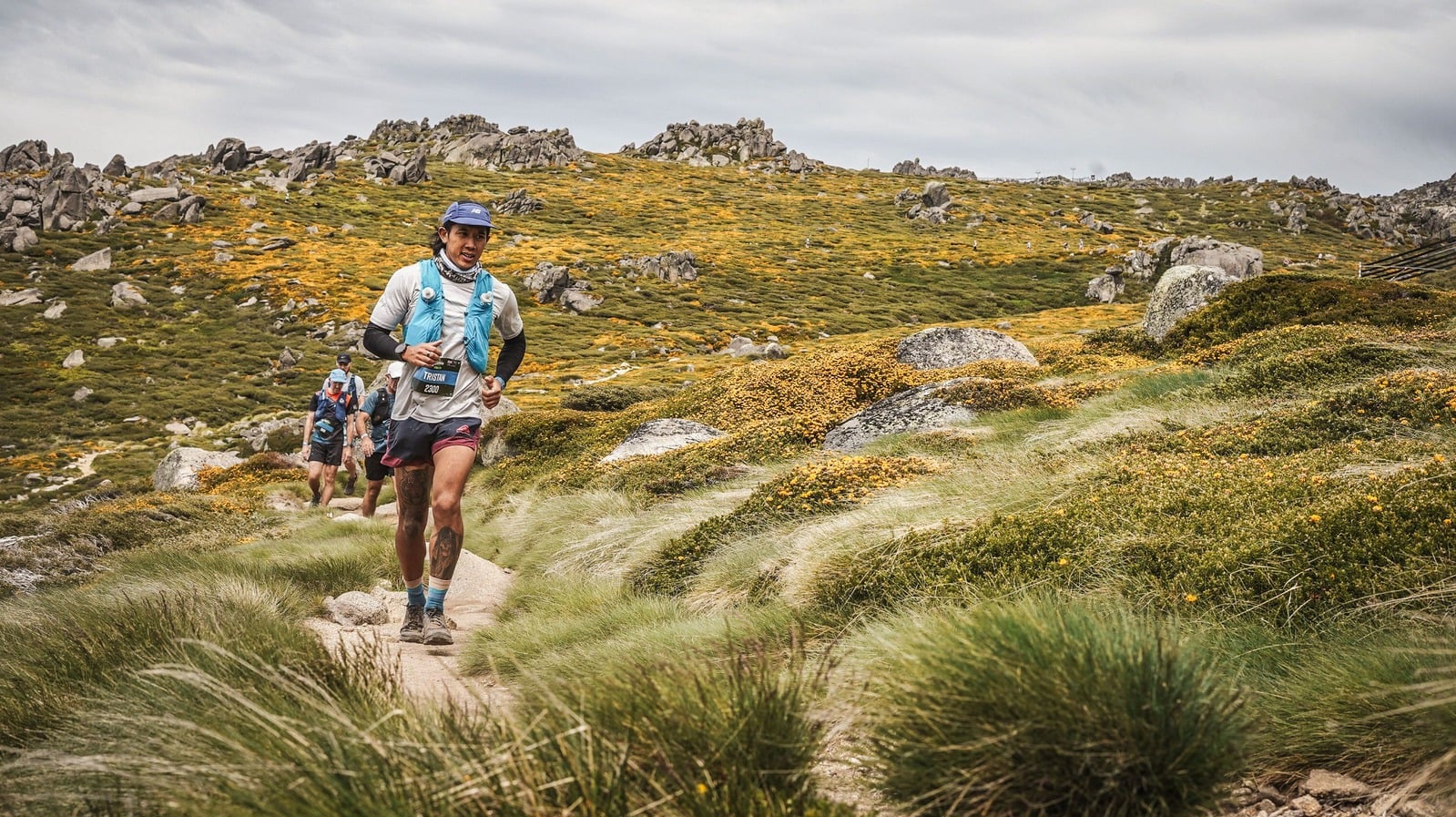 Tristan running a mountain trail through alpine grass